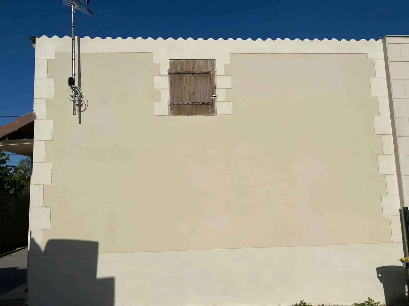 Pignon de maison en enduit crème avec encadrements imitation pierre