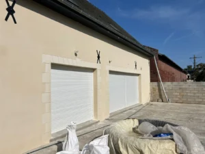 Façade de garage double en enduit crème avec encadrements imitation pierre