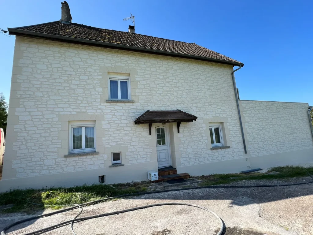 Maison avec façade en enduit imitation pierre blanche