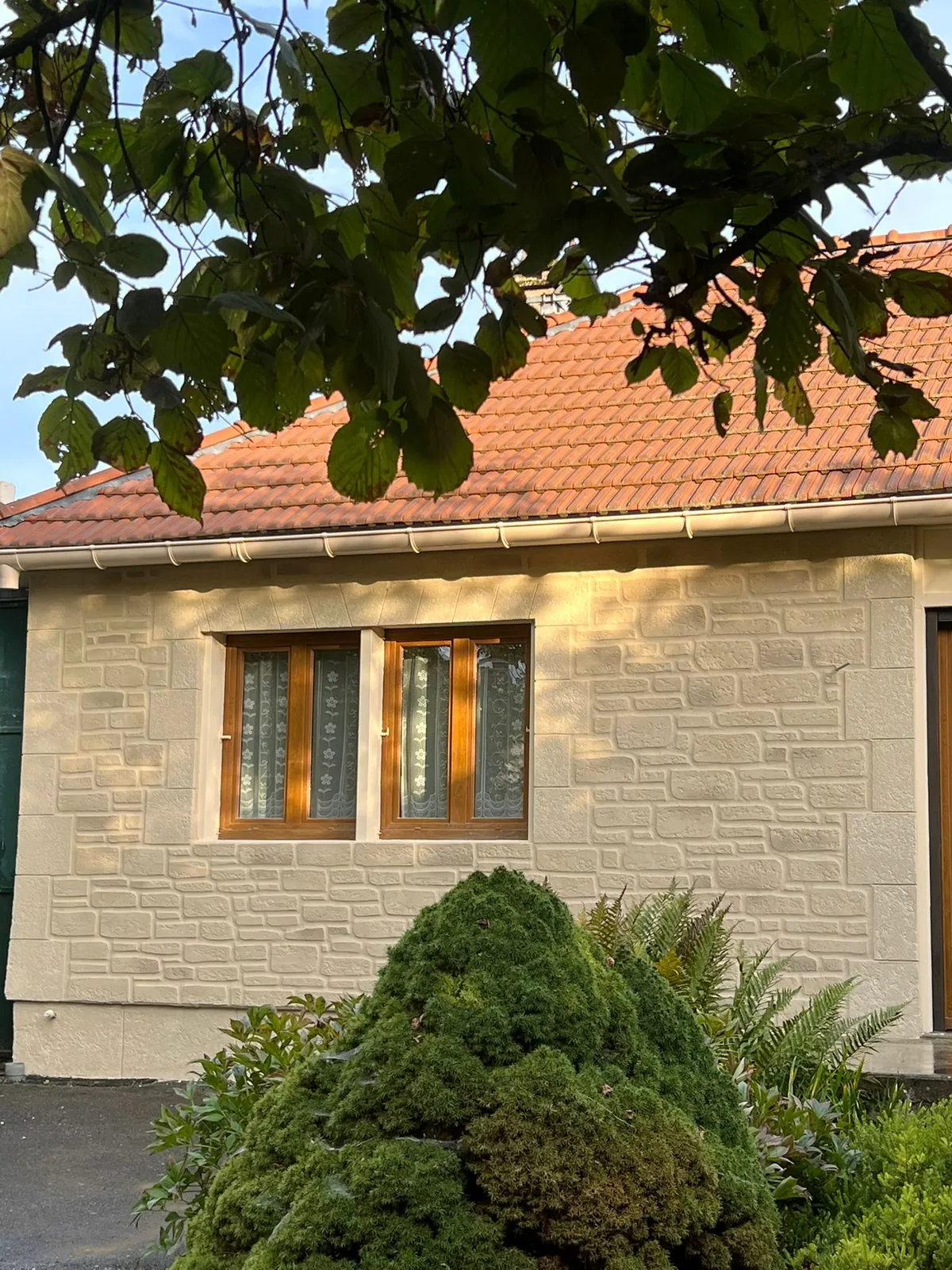 Façade en imitation pierre avec menuiseries en bois