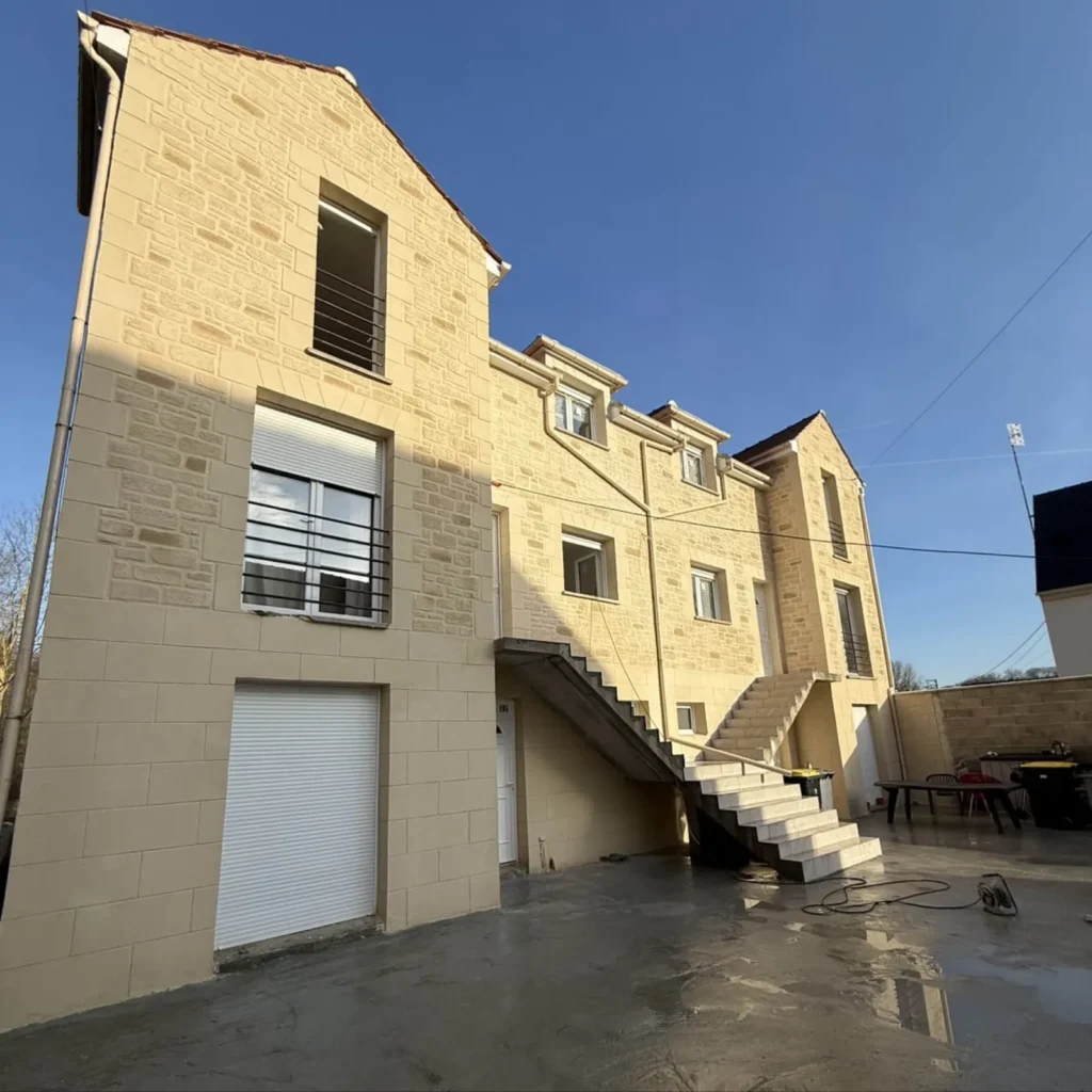 Immeuble avec façade en imitation pierre et escalier extérieur