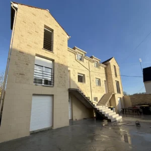 Immeuble avec façade en imitation pierre et escalier extérieur