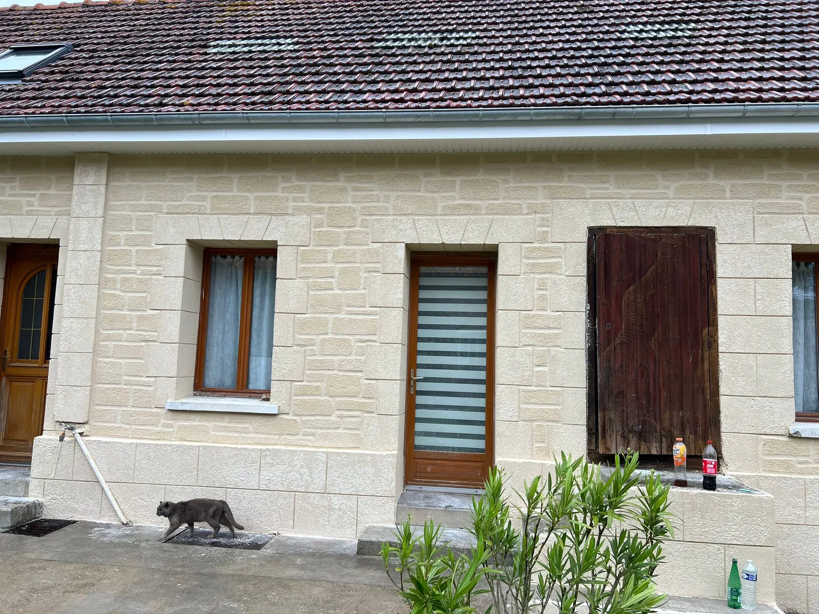 Maison de plain-pied avec façade en imitation pierre sous toit en tuiles