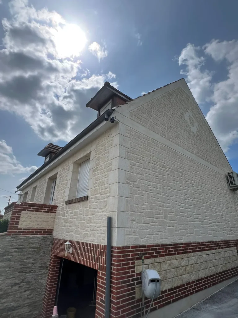 Pignon de maison en imitation pierre avec soubassement en brique