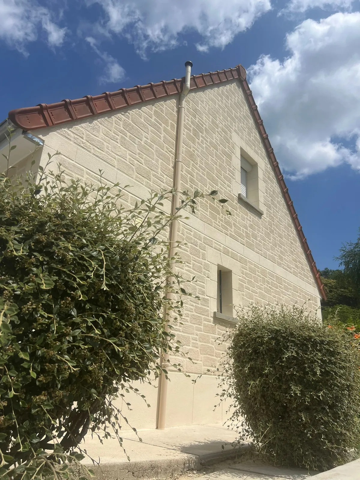 Pignon de maison en enduit imitation pierre taillée