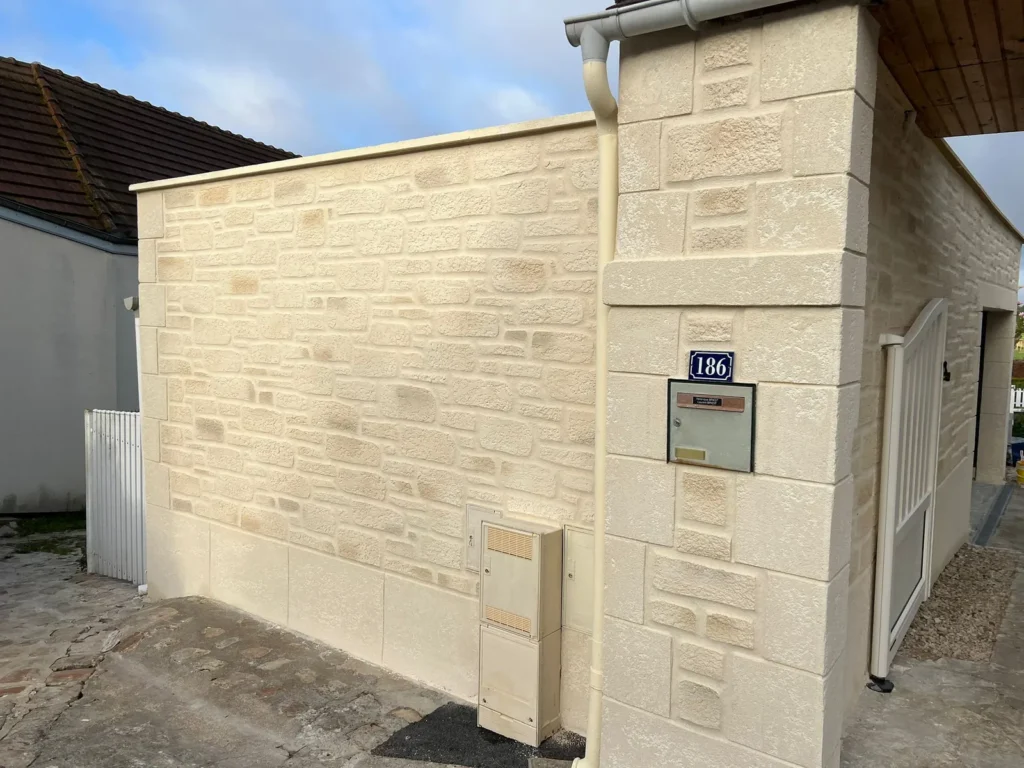 Mur de clôture en imitation pierre à l'entrée d'une maison