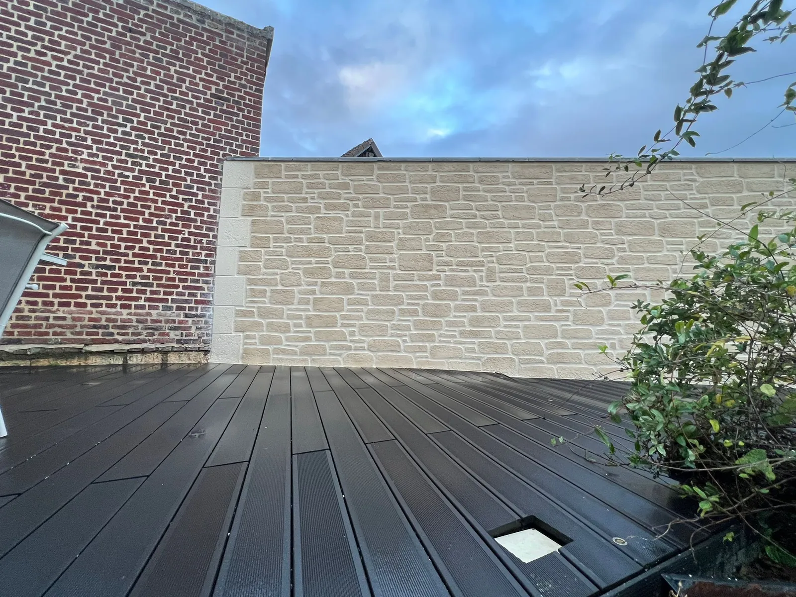 Mur en imitation pierre bordant une terrasse en bois