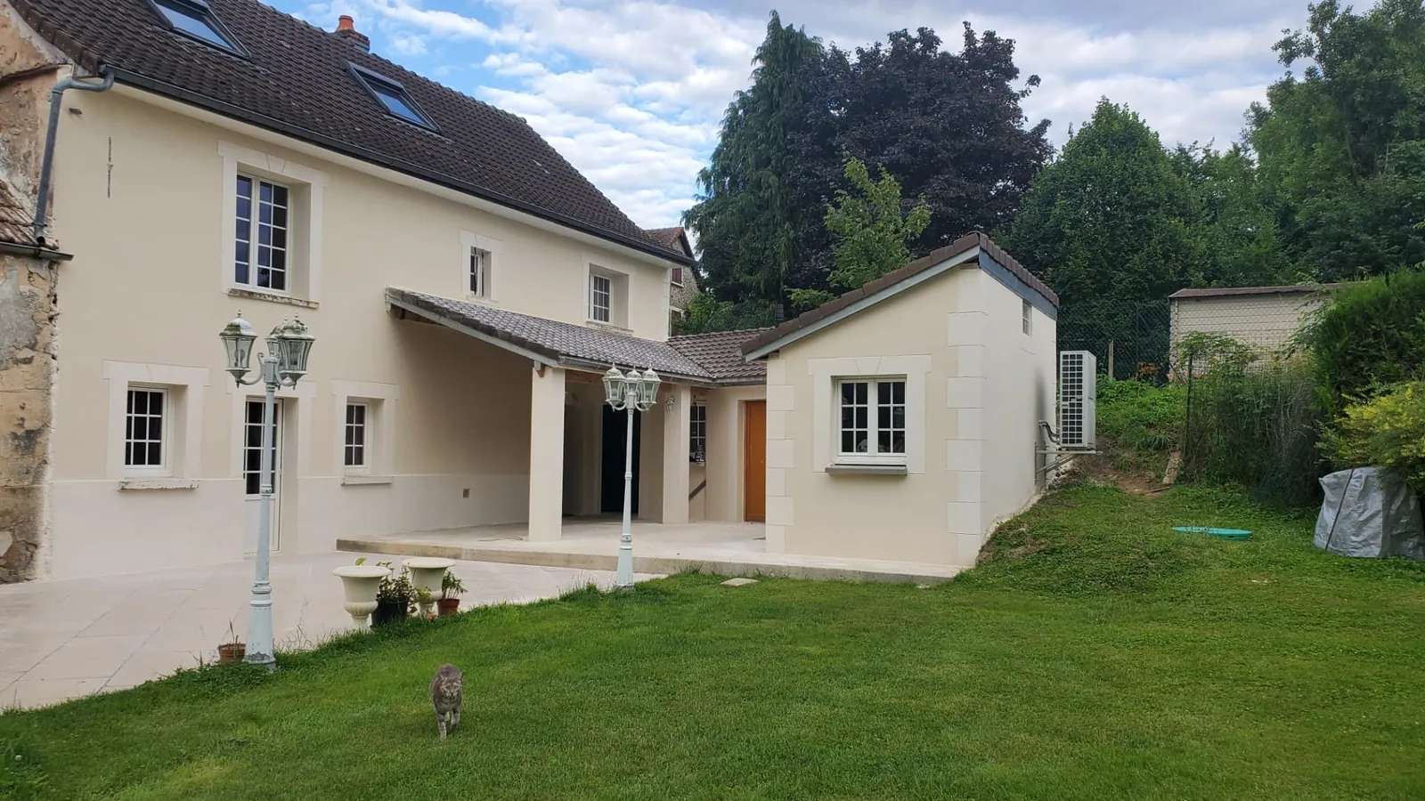 Maison ravalée en enduit beige avec jardin