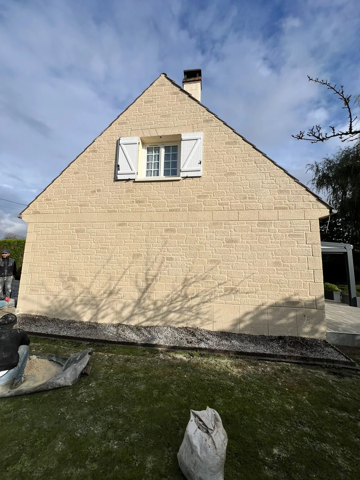 Pignon de maison ravalé en enduit beige clair