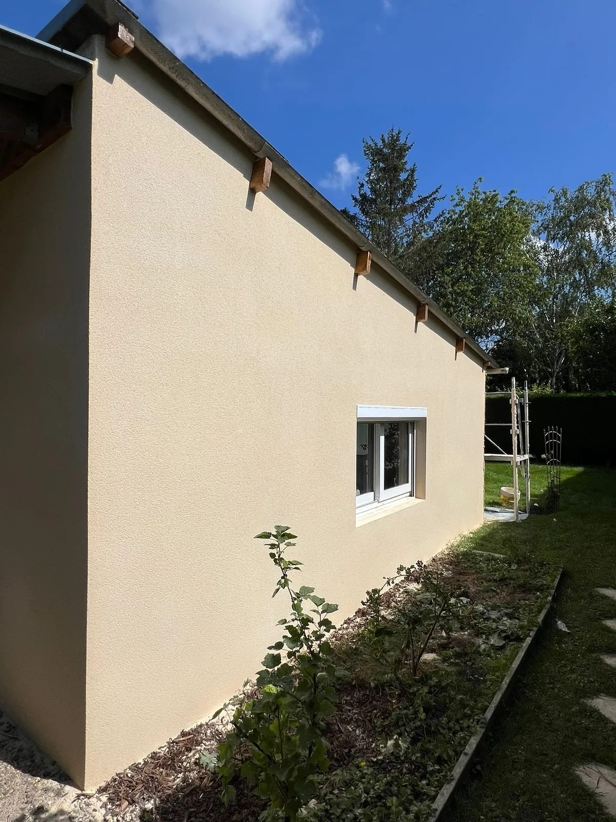 Pignon de maison ravalé en enduit beige dans l'Oise