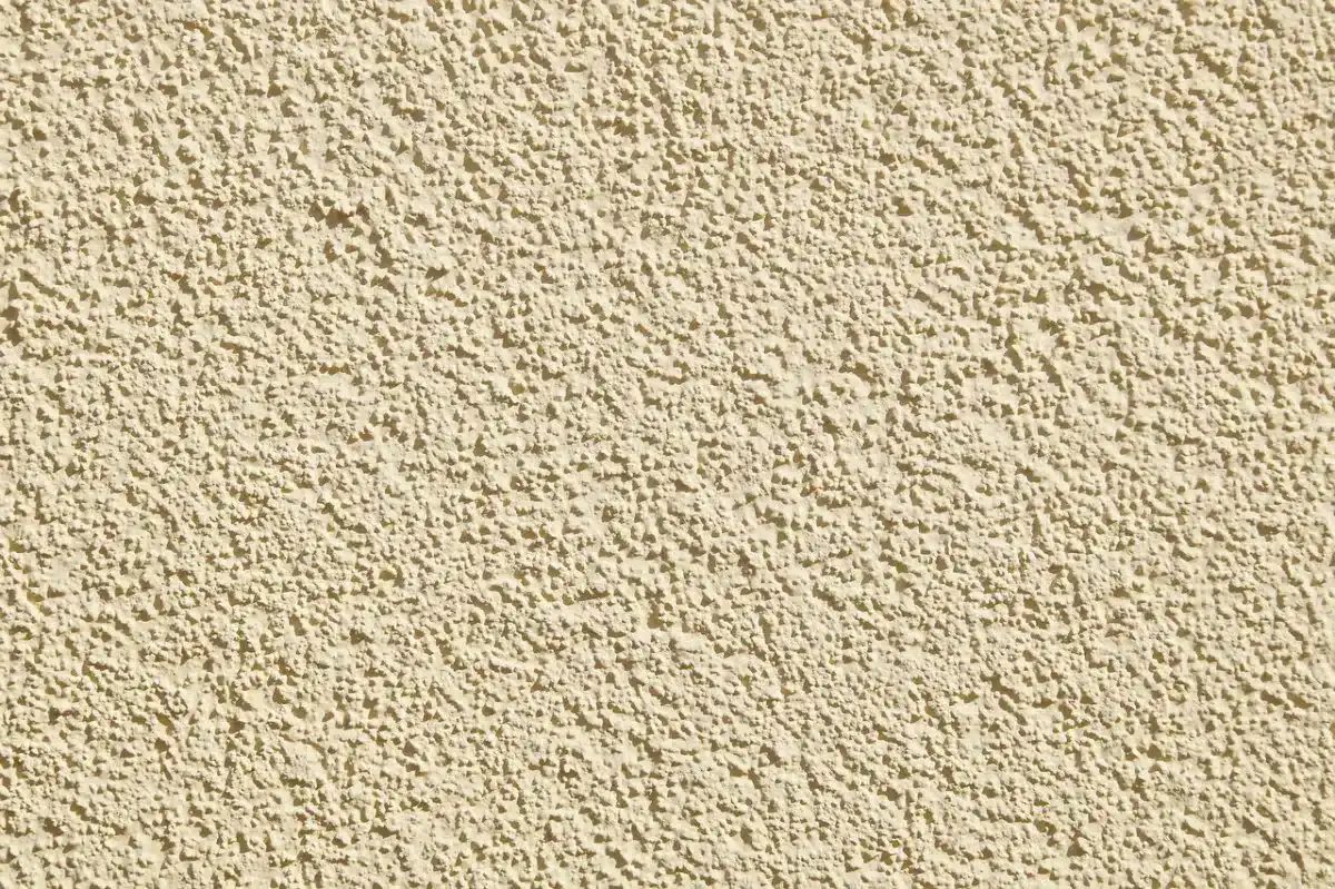 Texture d'enduit de façade beige à finition projetée